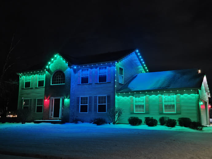 Multi-color LED accent lighting washing a two-story Stateline home in green, blue, and red, snow on the ground