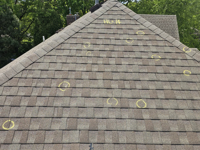 Hail damage marked on a roof during inspection