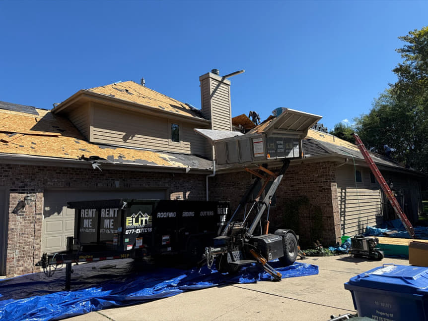 Our crew tearing off an old roof after a storm