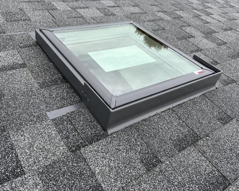 Finished skylight installation with black aluminum flashing on a grey asphalt shingle roof in Belvidere IL