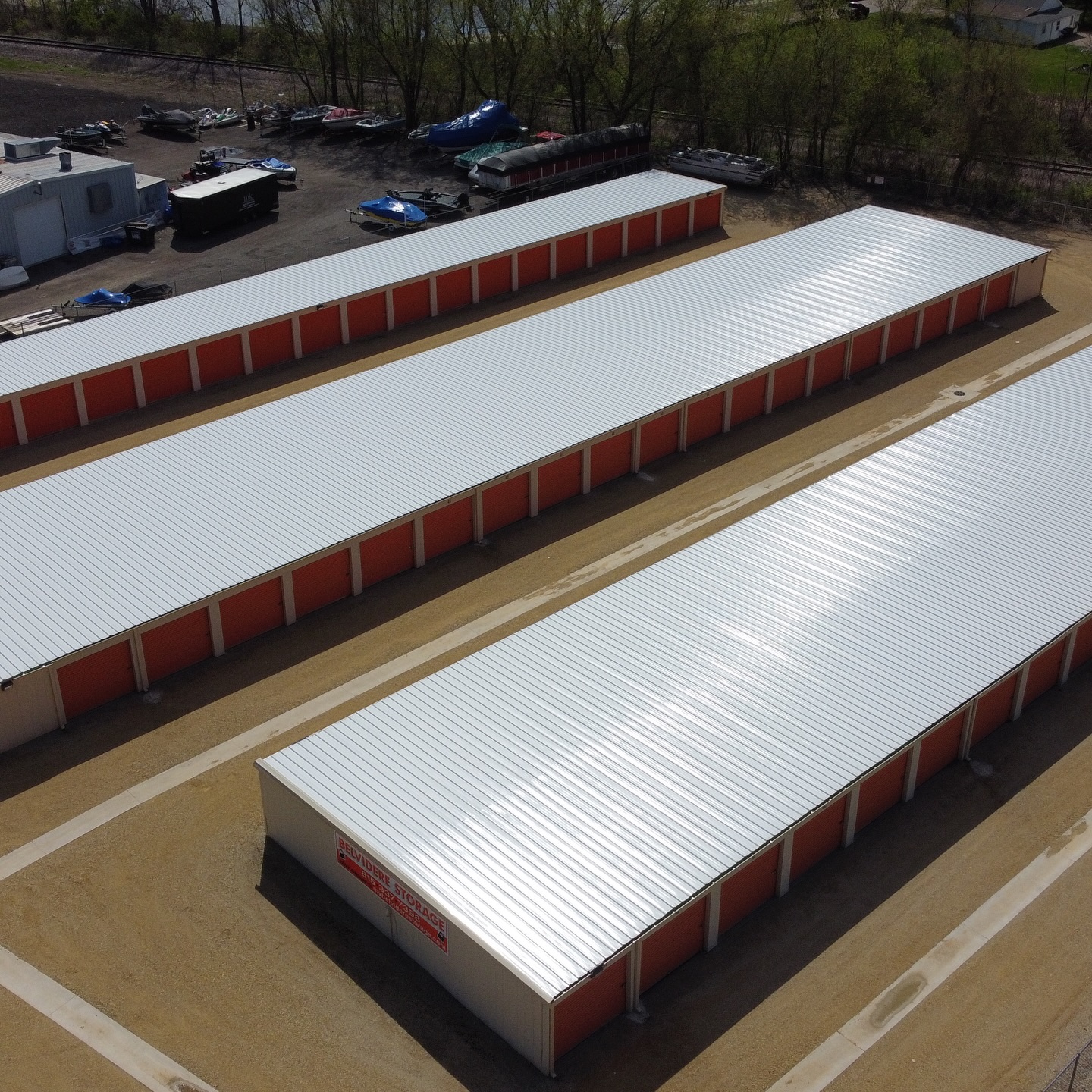 Aerial view of three commercial storage buildings with new white standing seam metal roofs in Belvidere, Illinois, installed by Elite Contracting Group