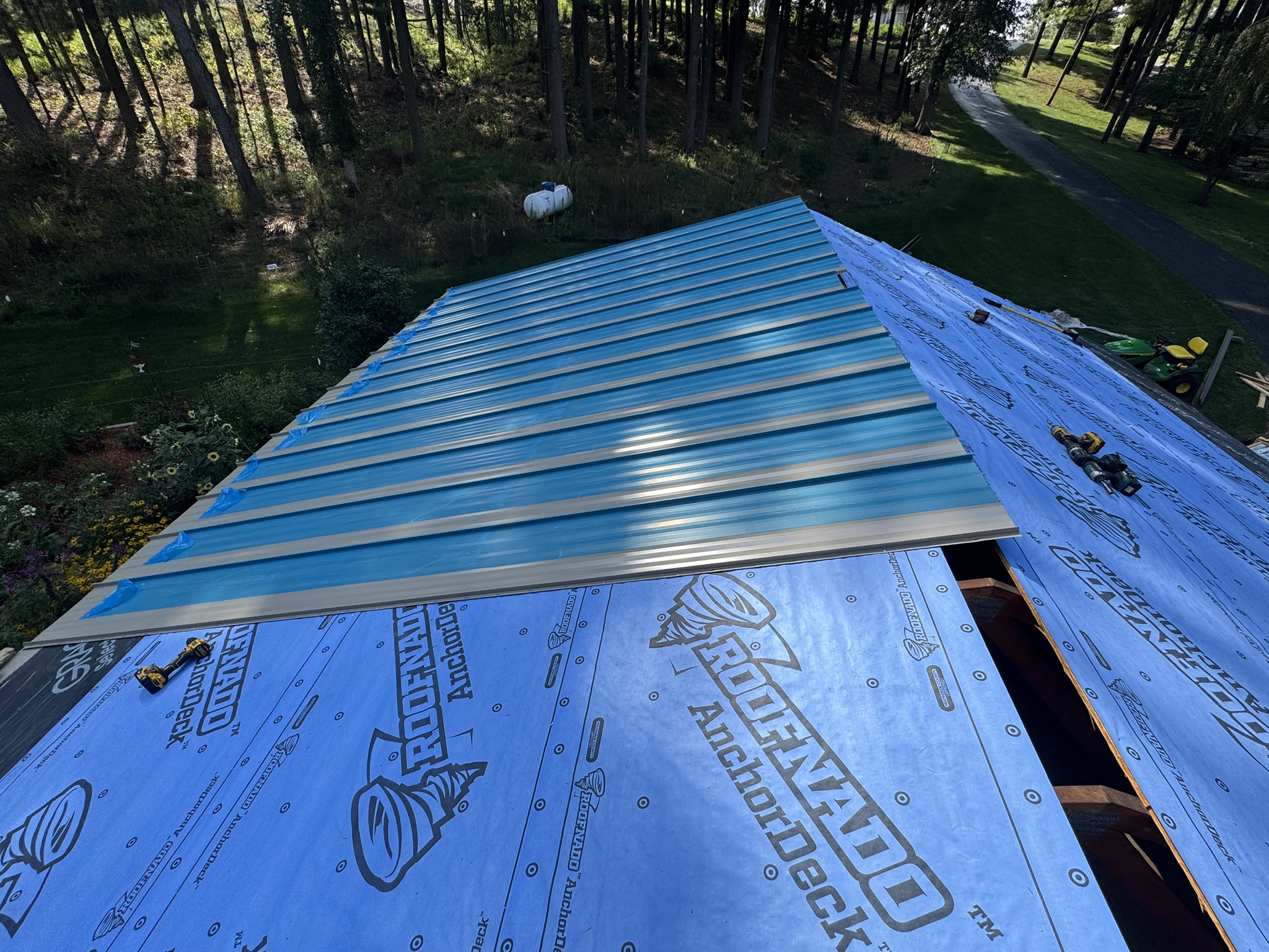 Standing seam metal panels going down over synthetic underlayment on a Wisconsin install by Elite Contracting Group