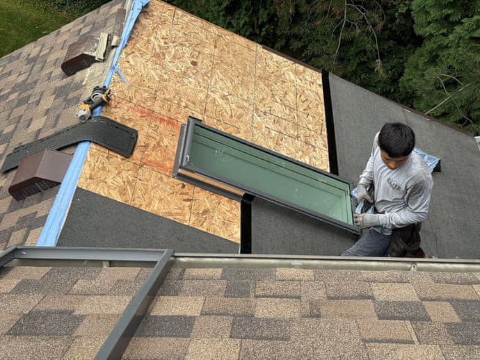 Fresh OSB sheathing swapped in around a dormer on an Elite Contracting Group roof replacement, ice and water shield run along the edge